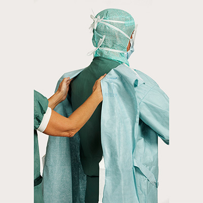 Surgeon and circulating nurse demonstrating step 4 of gown donning