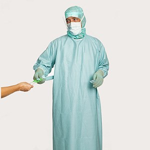 Healthcare professional demonstrating step 8 of gown donning