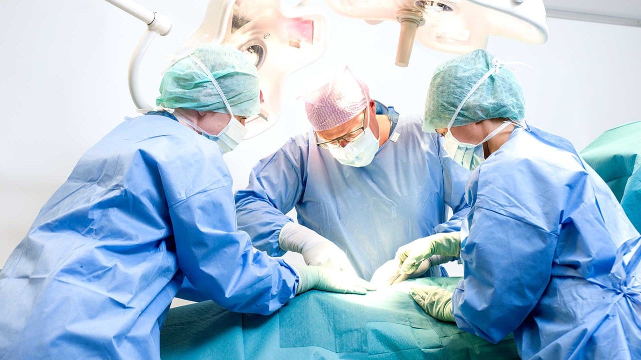 Surgeon and nurses operating in OR